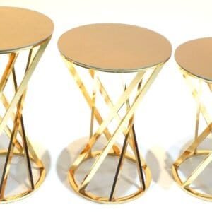Three gold-toned side tables with circular tops and intertwined geometric bases.