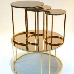 Four nesting tables with gold frames and mirrored tops, arranged in a cascading design.