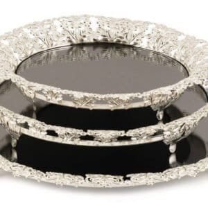 Intricate silver serving trays with ornate patterns stacked and showcasing metallic sheen.