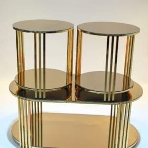 Modern side table with gold finish, two round tiers, vertical rods, and oval base shelf.