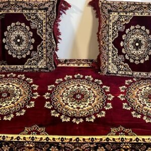 Traditional Persian cushions and rug with floral medallion designs on deep red background.