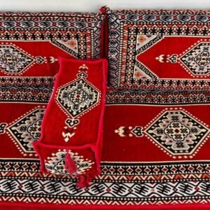 Red and black cushions with geometric patterns and intricate symmetrical designs.