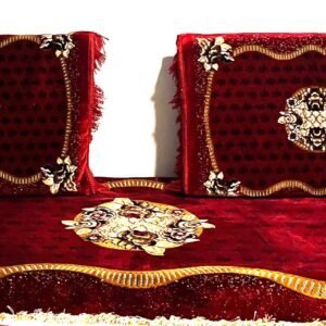 Two decorative pillows and a matching throw in red and gold with floral patterns.