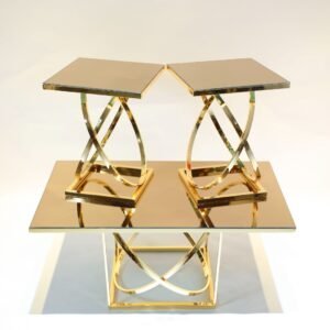 Reflective gold tables with geometric legs, tiered arrangement of two smaller on larger.