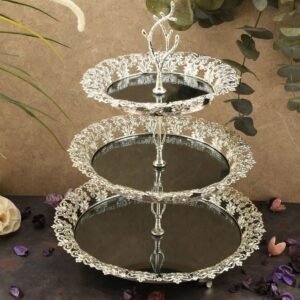Three-tiered metal stand with filigree, dried petals on neutral background.