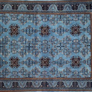 Decorative rug with blue background, intricate geometric patterns, and symmetrical motifs.