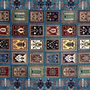 Decorative carpet with multiple square sections featuring geometric and floral designs.